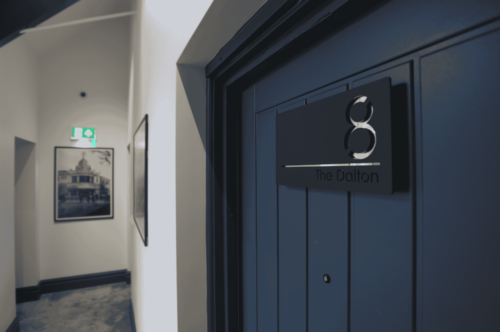 Detail of a blue door with the number 8 of a St David serviced apartment - About St David Aparthotels, Northern England